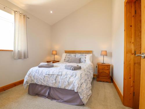 a bedroom with a bed with two lamps on it at Teal Cottage in Melton Mowbray