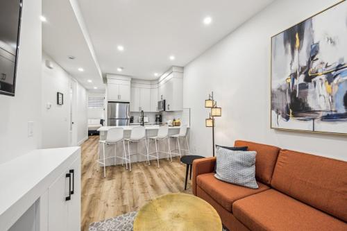 a living room with a couch and a kitchen at Ultimate Group Stay, 3 King Beds, 2 Suites in Calgary