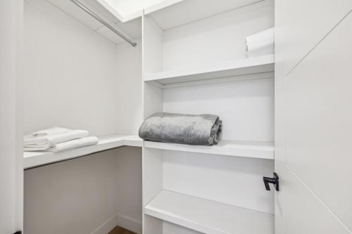 biała garderoba z torbą na półce w obiekcie Ultimate Group Stay, 3 King Beds, 2 Suites w mieście Calgary