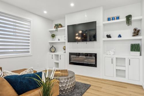 a living room with a couch and a tv at Ultimate Group Stay, 3 King Beds, 2 Suites in Calgary