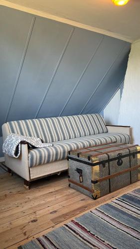 a couch and a trunk in a room at Solbacka in Mysinge