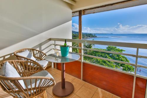 a balcony with a table and chairs and a view of the ocean at Blue Horizon - Le Luxury Matavai Beach - Piscine - Vue Mer in Arue