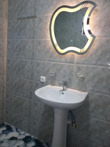 a bathroom with a sink and a mirror on the wall at sopo's cottage in Kobuleti