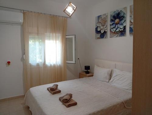 a bedroom with a bed with two slippers on it at Elina House 2 in Nikiti