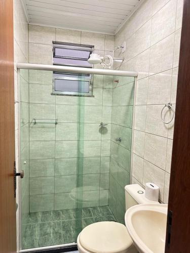 a bathroom with a shower and a toilet and a sink at Suíte Central in Nova Friburgo