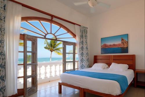 una camera da letto con un letto e una grande finestra di Hotel Albemarle Galapagos Beachfront a Puerto Villamil
