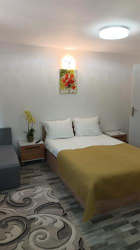 a bedroom with a bed and a couch and a picture at Casa EDI in Ferihaza