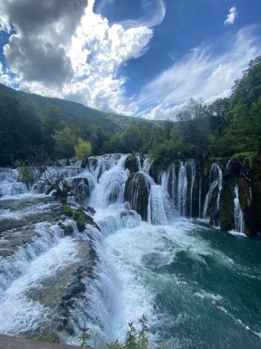 a waterfall in the middle of a river at Apartman Azra in Kulen Vakuf