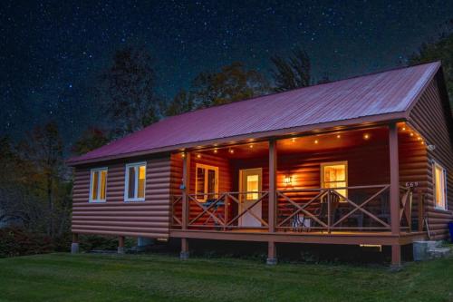a log cabin with a red roof at night at Cozy Cabin in Stratton Mountain & Mount Snow 10min in Stratton