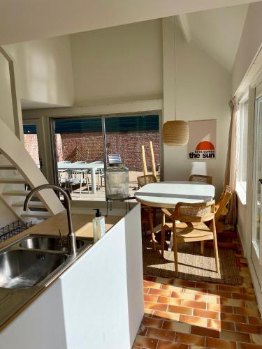 a kitchen and dining room with a table and chairs at Holiday home close to beach and Keukenhof in Noordwijkerhout