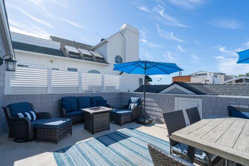 a patio with chairs and a table and an umbrella at 304 Ruby Ave B in Newport Beach