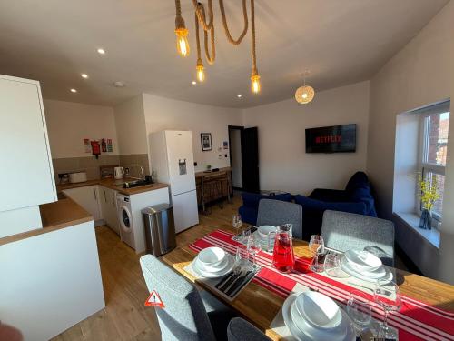 a kitchen and a living room with a table and chairs at The Anfield Loft in Liverpool