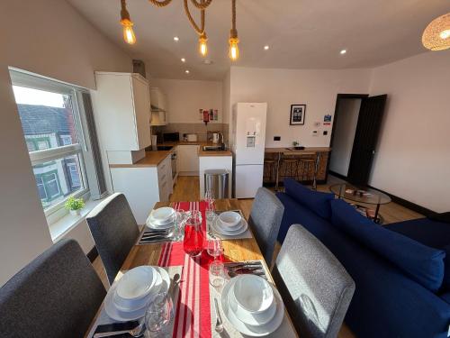 a dining room with a table and chairs and a kitchen at The Anfield Loft in Liverpool