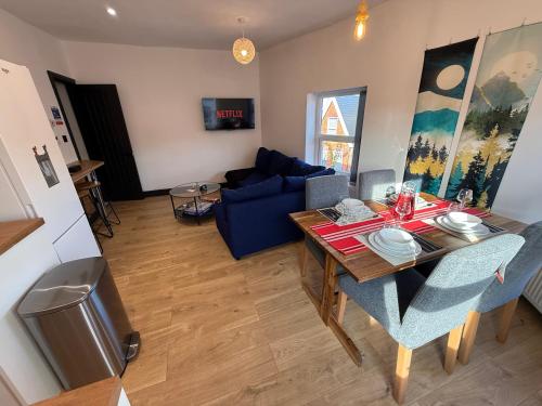 a living room with a table and a blue couch at The Anfield Loft in Liverpool