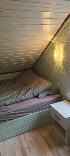 a bed in a small room with a table at Utsikten in Havningberg