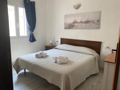 una camera da letto con un letto con asciugamani sopra di Agrustos Paradise a Budoni