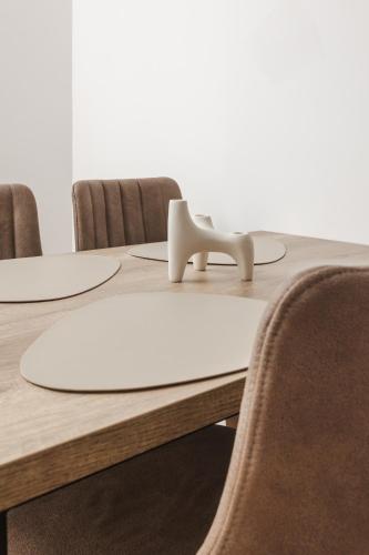 a table with chairs around it with a white object on it at Autentica Apart in Cetinje