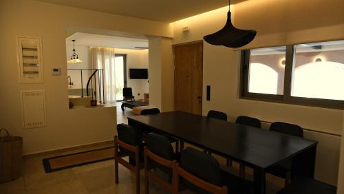 a dining room with a black table and chairs at Trabala Ionian Living in Paleros