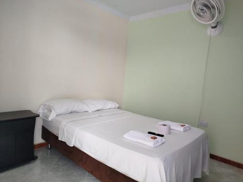 a bedroom with a bed with towels and a fan at Casa turistica Portones del mirador in Monterrey
