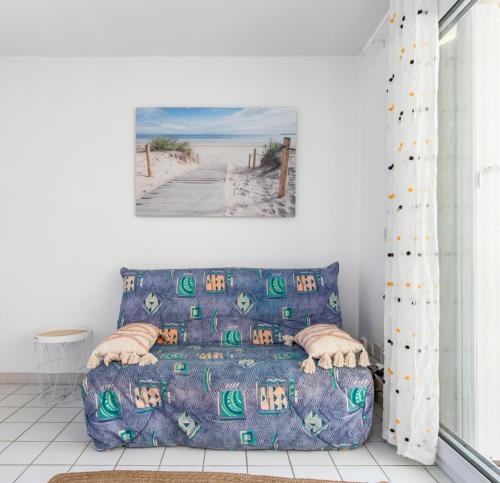 ヴァルラ・プラージュにあるLe Sirocco - Parking - Terrasse - Accès plageのビーチの絵が飾られたリビングルームのソファ