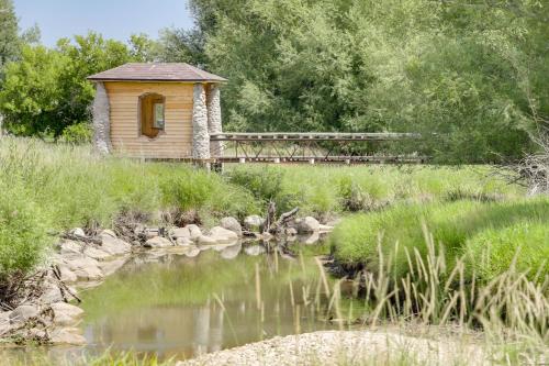 a small building next to a pond with a bridge at Stunning Sheridan Ranch Villa Mountain View! in Sheridan