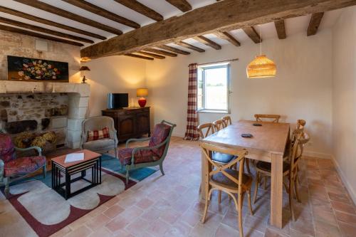 un salon avec une table et des chaises et une cheminée dans l'établissement Le Puits Renaissance - Gîtes de caractère et piscine chauffée, à Chambourg-sur-Indre