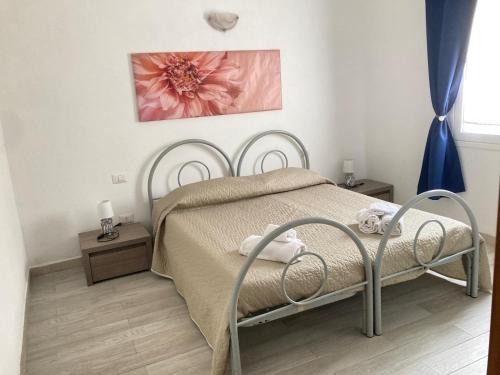 una camera da letto con un letto con un fiore rosa sul muro di Agrustos Paradise a Budoni