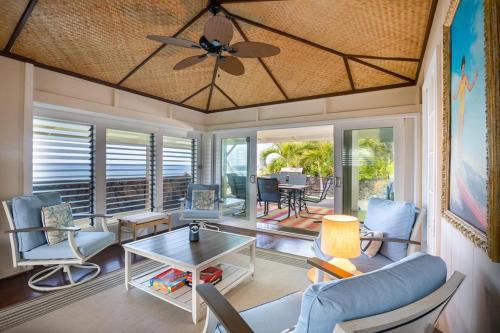 カイルア・コナにあるHonl's Beach Hale (Big Island)の天井ファンとテーブルのあるリビングルーム