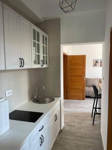 a kitchen with white cabinets and a sink at Quattro Rocce Apartments Zelen in Sutomore