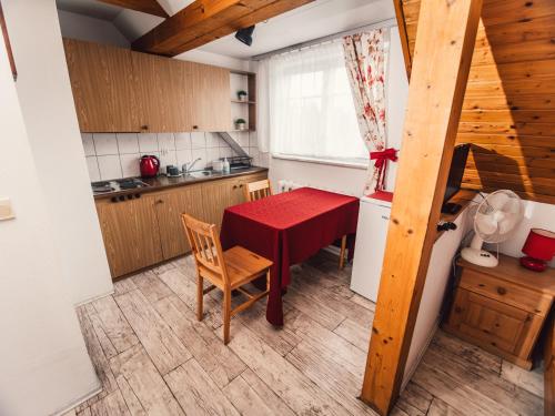 a small kitchen with a red table and chairs at Šilainė Glamping & SPA, Padel court in Oszkinie