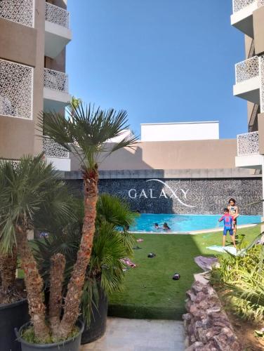 a swimming pool in the middle of a building with palm trees at Dar Fatma Luxury apartment with sea view in Hammamet Sud
