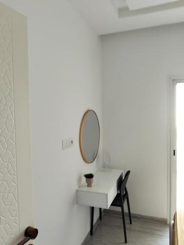 a mirror on a wall next to a white table at Dar Fatma Luxury apartment with sea view in Hammamet Sud