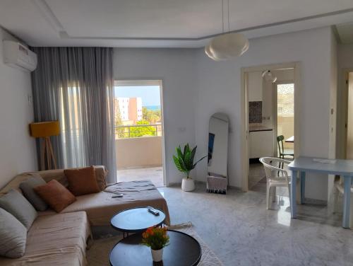 a living room with a couch and a table at Dar Fatma Luxury apartment with sea view in Hammamet Sud