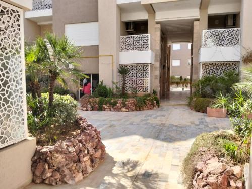 a courtyard of a building with trees and plants at Dar Fatma Luxury apartment with sea view in Hammamet Sud