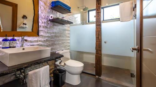 a bathroom with a white toilet and a sink at Tilajari Hotel Resort in Fortuna