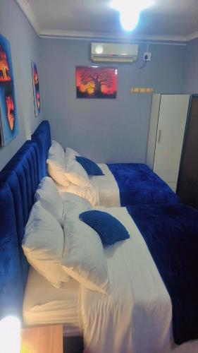a bedroom with a large bed with pillows on it at Royal Blue Family Haven in Rustenburg