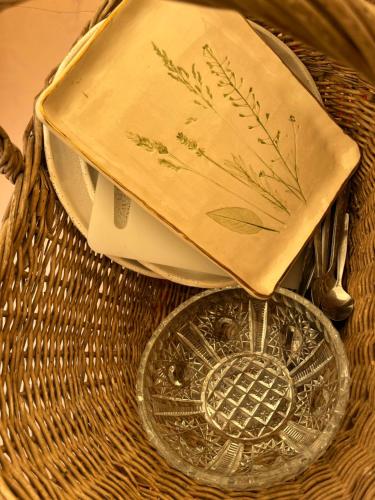 a wicker basket with a plate and a napkin at KEMPINGS Kareļi in Liepāja