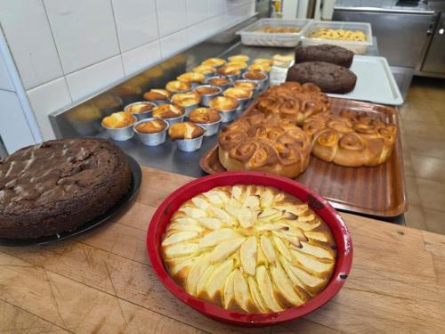 a table with a bunch of different types of donuts and pastries at Hotel De la Ville in Andalo