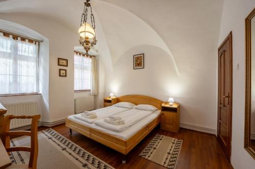 a bedroom with a bed and a chandelier at Pensiunea Bastion - La Strada - in Sighişoara