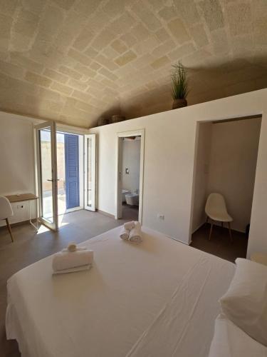 a bedroom with a white bed with a plant on the ceiling at Le Suite del Vicolo FAVIGNANA CENTRO in Favignana