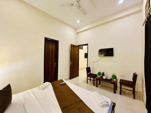 a bedroom with a bed and a table and a desk at Oxygen Inn-Couple Friendly-Noida Sector51 in Noida
