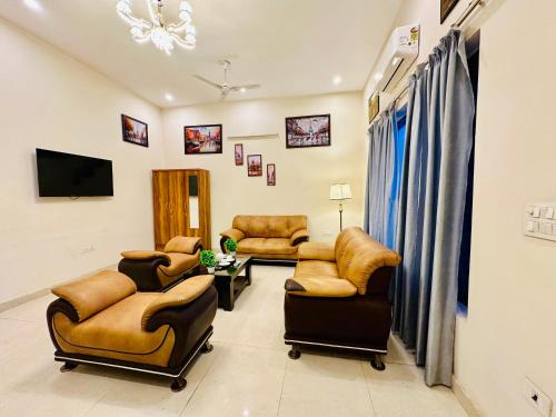 a living room with couches and chairs and a television at Oxygen Inn-Couple Friendly-Noida Sector51 in Noida