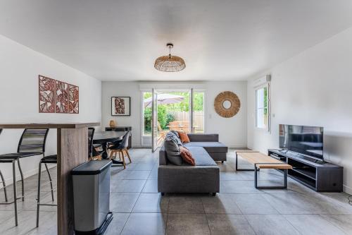 un salon avec un canapé et une télévision dans l'établissement Pretty wooden house with terrace - Bassin d'Arcachon, à Arès