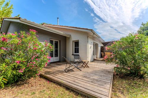 une terrasse en bois avec deux chaises sur une maison dans l'établissement Pretty wooden house with terrace - Bassin d'Arcachon, à Arès
