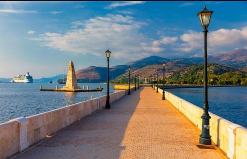 a pier with street lights and a sailboat in the water at ELENA SEAVIEW house in Argostoli