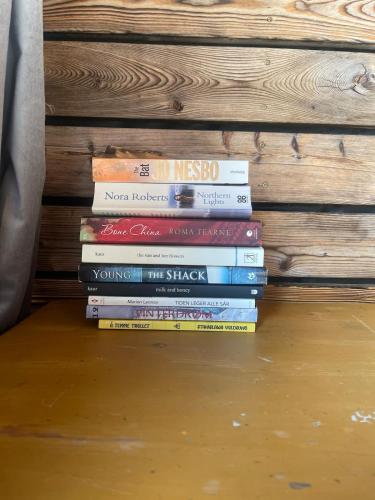 a stack of books sitting on the floor at Forest Hideaway With Scenic View in Fiskå