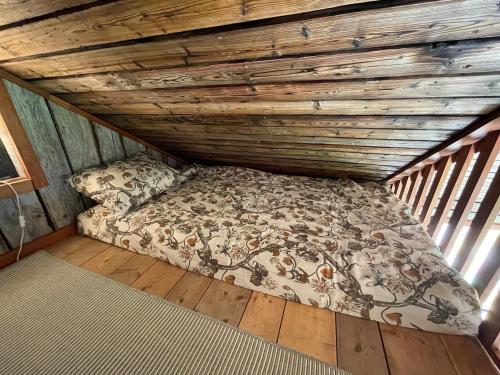 a bed in a room with a wooden ceiling at Forest Hideaway With Scenic View in Fiskå