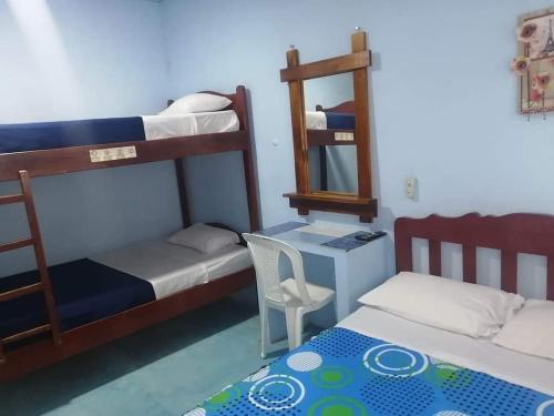 a small room with two bunk beds and a mirror at Hostal Aruba in Atacames
