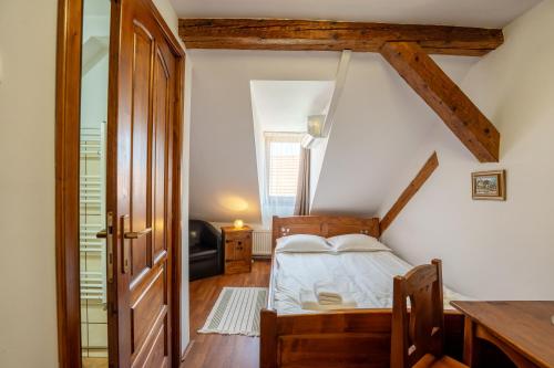 a bedroom with a bed and a desk in a room at Pensiunea Bastion - La Strada - in Sighişoara