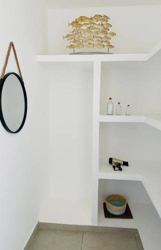 a room with white shelves and a mirror at The sunrises are lovely, and the privacy is exceptional in Sipacate
